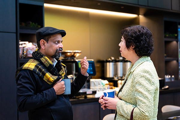 A man and a woman talking over a cup of coffee.